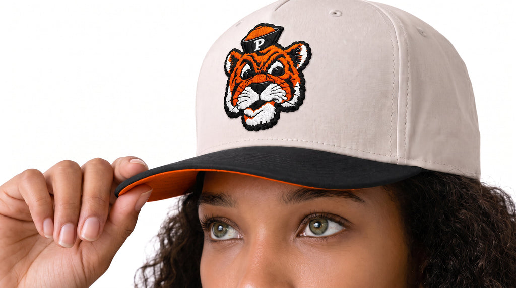 Woman tipping a University of the Pacific Project 1851 Tommy Tiger Snapback with an embroidered Tommy Tiger, warm gray crown and black visor
